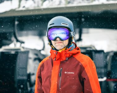 a man wearing a helmet and goggles standing in the snow