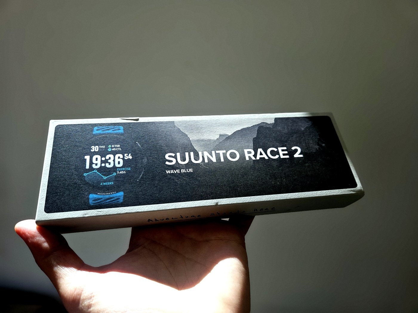 קופסת האריזה של Suunto Race 2 בגוון Wave Blue מוחזקת ביד