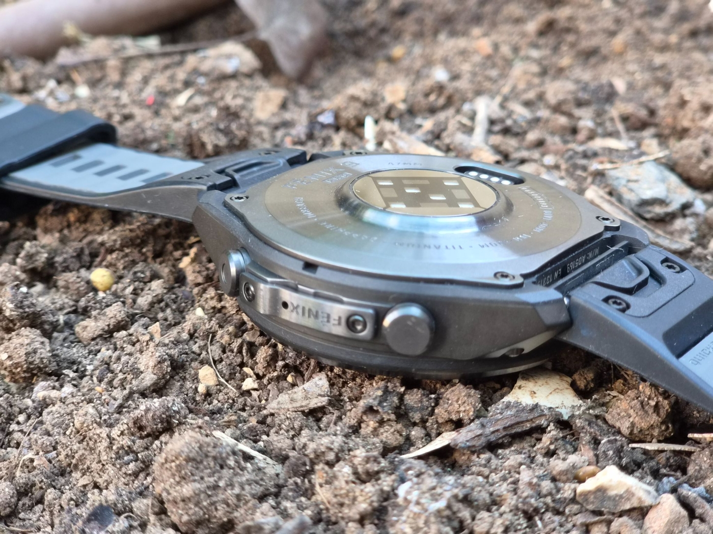 גב ודופן Fenix 9 Pro מונחים על אדמה בשטח